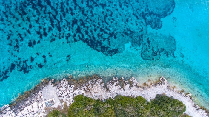 Imagen aérea del litoral de las Islas Cíes, con aguas cristalinas que reflejan la riqueza y fragilidad del ecosistema marino.