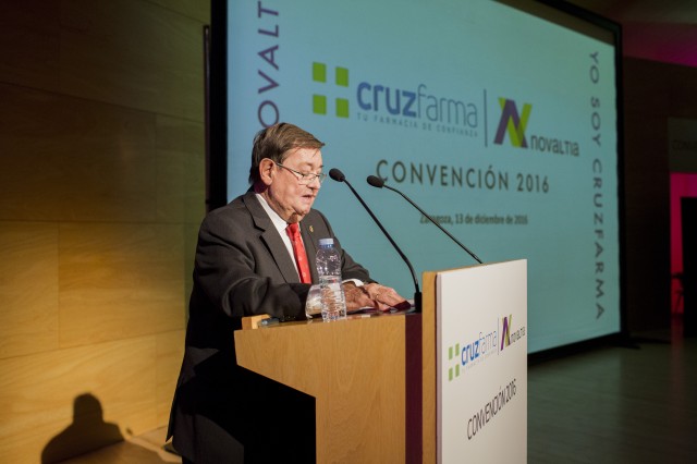 Imagen del acto celebrado en la Convención anual de Novaltia, en el que se expusieron las líneas estratégicas y la nueva cartera de servicios Cruzfarma para las farmacias socias. La fotografía muestra una intervención del presidente en el atril con la proyección corporativa de la convención al fondo.