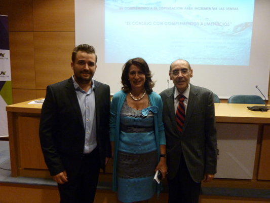 En la imagen, tres participantes del workshop celebrado en la sede de Novaltia en Zaragoza posan juntos tras la sesión dedicada al consejo farmacéutico en complementos alimenticios. Al fondo se proyecta la presentación titulada “El consejo con complementos alimenticios"