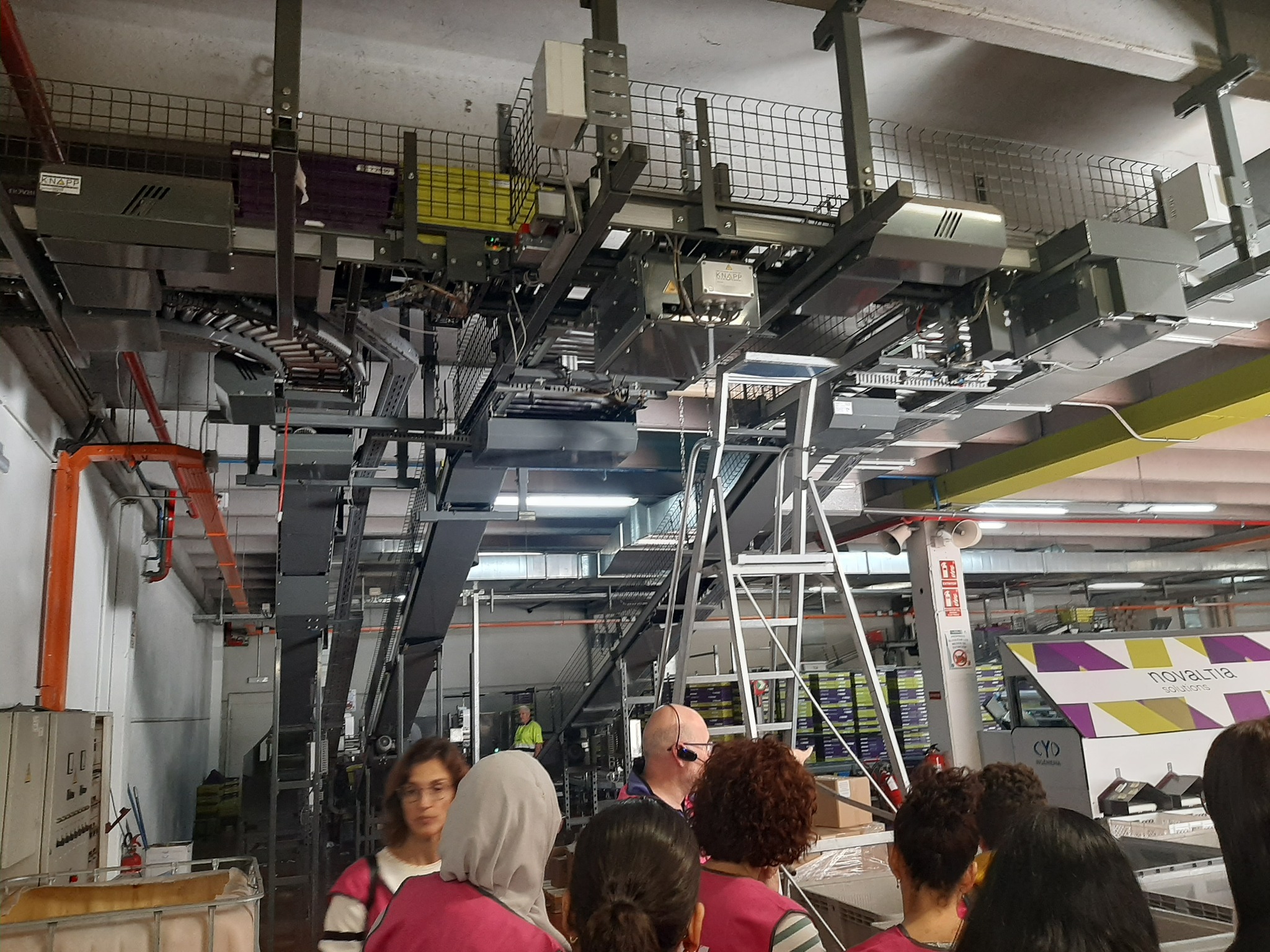 Alumnado del IES Río Gállego observando el sistema automatizado del centro logístico de Novaltia durante la visita guiada.